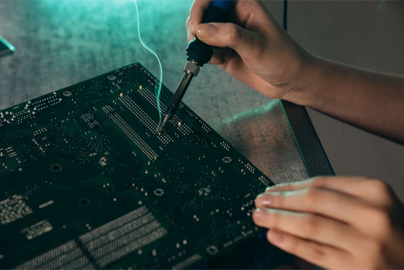 Engineer soldering an electronic circuit board